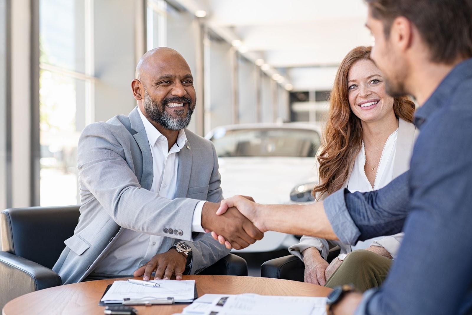 A happy couple buying a new car, demonstrating the ease and flexibility of long-term car rental options